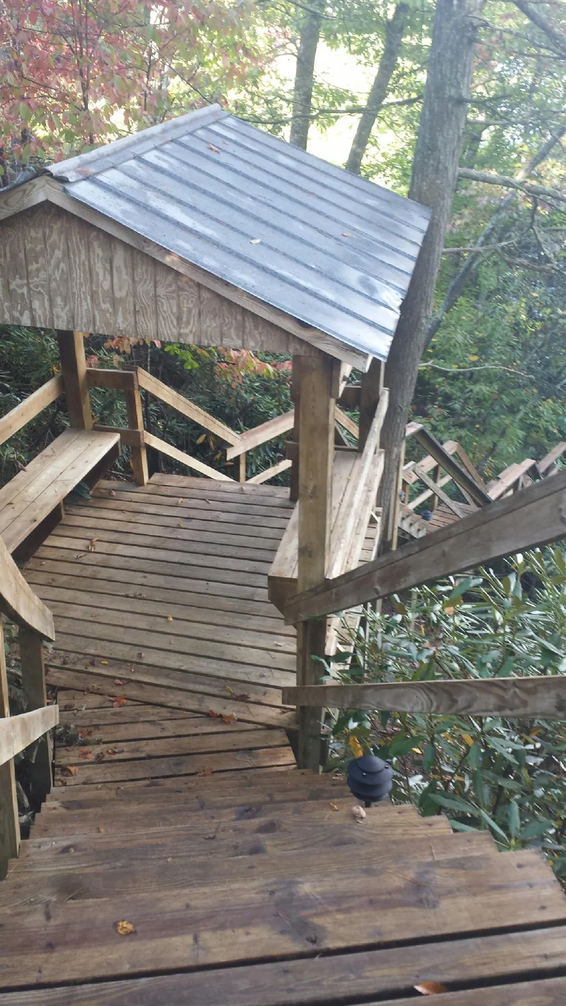 Metal roofed shelter over wooden steps on a wooded walkway — Skylight Repair & Installation work by our crew in Warrenton